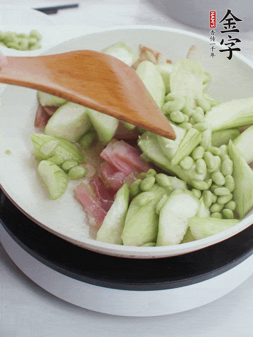 依次下絲瓜、青豆翻炒，炒至絲瓜打蔫縮小。