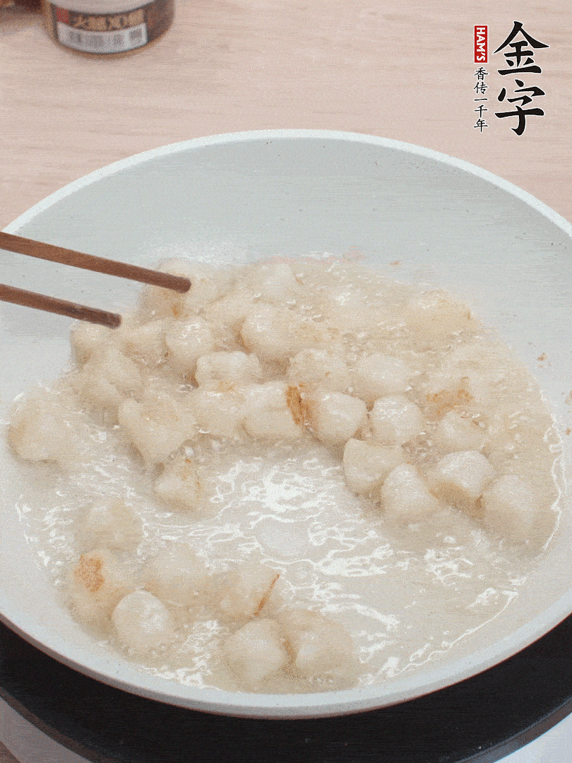 油溫4成熱，鮮貝蘸干淀粉下鍋煎，一面微黃后翻面。