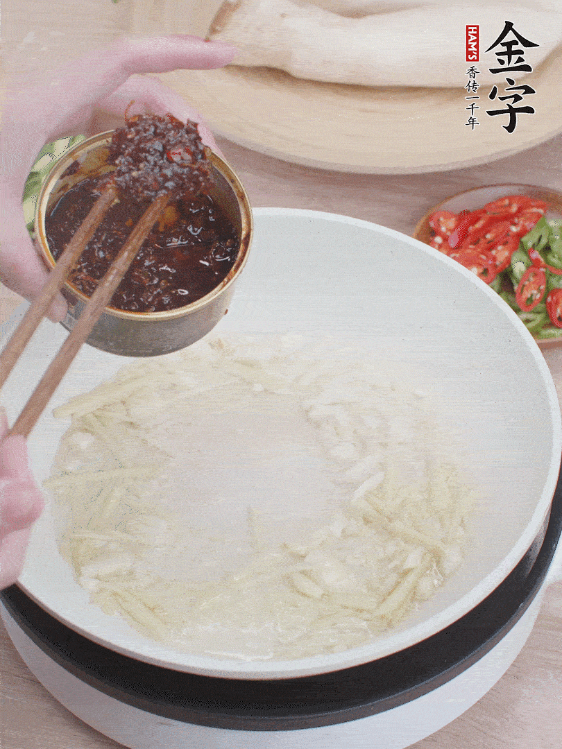 起鍋熱油，姜蒜、金字火腿干貝醬煸香。