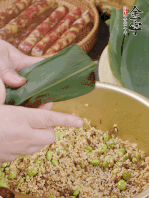 粽葉往下折，完全蓋住，兩側(cè)捏緊。