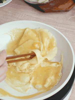 油6成熱時(shí)，下雞蛋液，邊緣凝固時(shí)翻拌成塊狀。