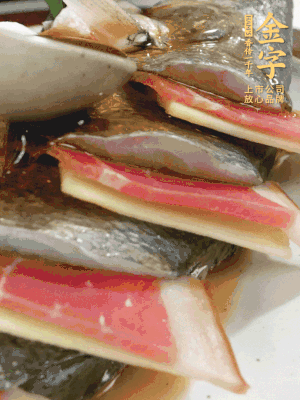 魚肚中塞蔥結(jié)、火腿片，魚身上碼放姜片、火腿片，倒入混合的料汁。
