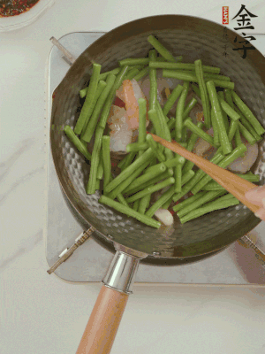 下掰好的缸豆段翻炒，略燜煮。