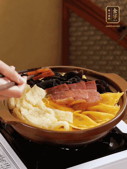 砂鍋底部鋪上娃娃菜，依次擺上肉皮、蛋餃、黑木耳、火腿